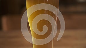 Beer. Cold Craft light Beer in a glass with water drops. Pint of Beer close up on a wooden background.