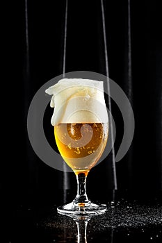 Beer. Cold Craft light Beer in a glass with water drops. Pint of Beer into a tall glass with a thick foam