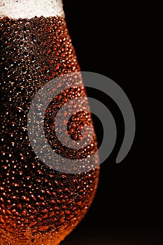 Beer. Cold Craft light Beer in a glass with water drops on the wooden table over the black background