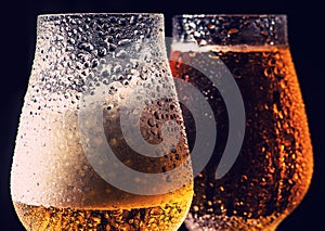 Beer. Cold Craft light Beer in a glass with water drops on the wooden table over the black background