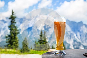 Beer. Cold golden draft beer in glass over alps. Tasty beer and tourist season in the mountains or the Alps