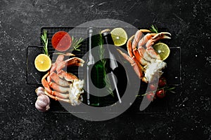 Beer and crab claws on a black background. Rustic style.