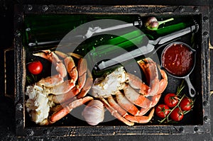 Beer and crab claws on a black background. Rustic style.