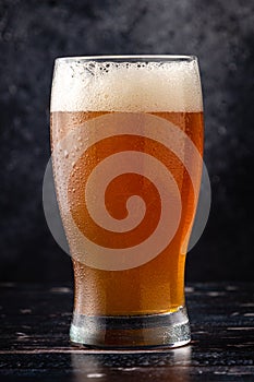 Beer on dark background with water droplets