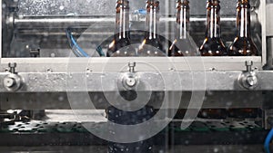 Beer factory. A part of automatic beer production techological cycle. Empty bottles are washed before filling with beer