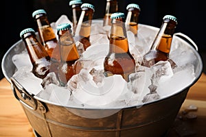 Beer filled bottles chill inside pail cradled by ice for refreshing coolness