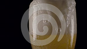 Beer foam pouring over cup edge.