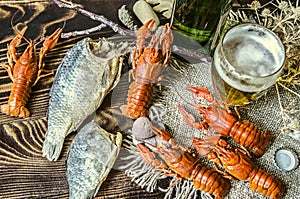 Beer in a glass and a bottle of beer with a snack of boiled craw fish and dried salted fish