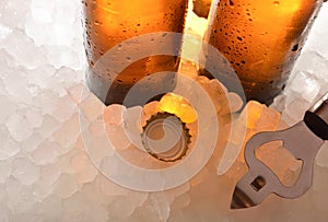 Beer glass bottles on ice with cap and bottle opener