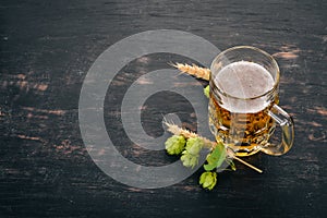 Beer in a glass mug. On a black wooden table.