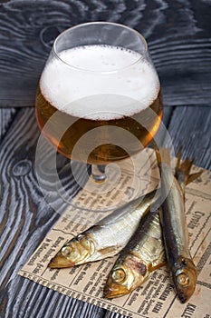 Beer in a glass and smoked fish. On pine boards. A day without diets