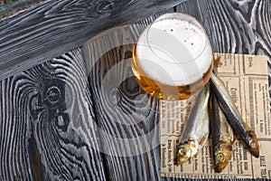 Beer in a glass and smoked fish. On pine boards. A day without diets