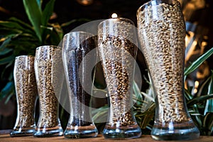 Beer glasses filled with different malts and hops, close-up