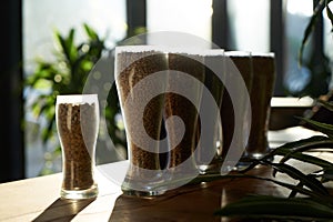 Beer glasses filled with different malts and hops, close-up