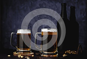Beer glasses with lager, dark lager, brown ale, malt and stout beer on table, dark wooden background