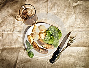 Beer with grilled sausages and roasted potato. Vintage style