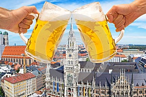 Beer mugs cheers with Munich Marienplatz in background photo