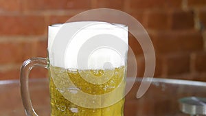 Beer in a large glass mug with high foam very close up