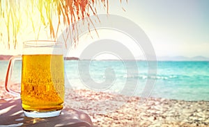 Beer in mug on beach photo