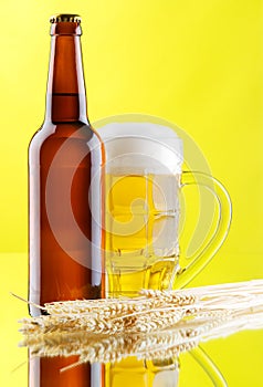 Beer mug and bottles on yellow background