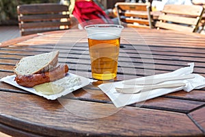 A mug of beer and sausage on the table