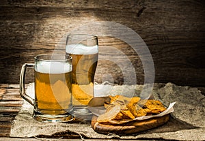 Beer in a mug, glass , chips on board