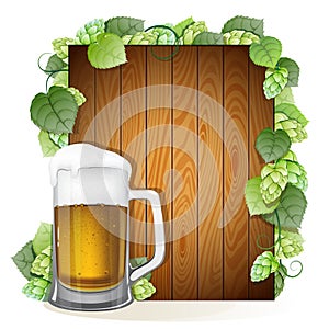 Beer mug and hops branch on a wooden background