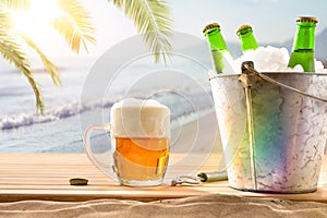 Beer mug and ice bucket filled with beer bottles beach