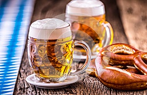 Beer. Oktoberfest.Two cold beers and pretzel. Draft beer. But draft. Golden beer. Golden however. photo