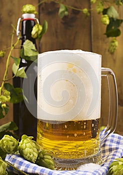 Beer. Pint of Beer close up on a wooden background. Cold Craft light Beer in a glass with water drops. Beer is pouring