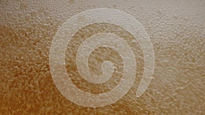 Beer is poured into a glass of beer, creating many bubbles.