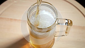 Beer is poured into a glass goblet. Slow motion