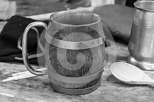 Beer is poured into a wooden mug in the form of an oak barrel, a wooden spoon lies next to it, pub design