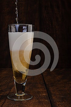 Beer served in a glass with rustic wood background