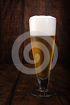 Beer served in a glass with rustic wood background