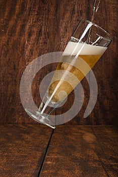 Beer served in a glass with rustic wood background
