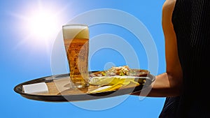 Beer served by a waitress hot sun blue sky holidays background
