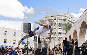 Beer-Sheva, ISRAEL - March 5, 2015:Two men, clowns, gymnasts, one of them in a tutu on the open stage - Purim