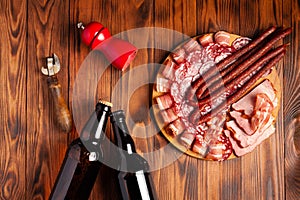 Beer snack in the form of meat products and bottled beer. Appetizer in the form of slicing bacon, salami, ham, hunting sausages.