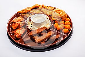 Beer snack: spicy chicken wings  cheese balls  fried black bread toast with garlic  onion rings in batter. Snack on a white