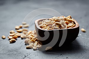 beer snack, wooden bowl with roasted peeled peanuts