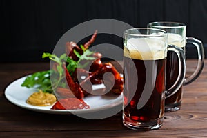 Two mugs of dark beer with delicious hot crusty grilled chicken