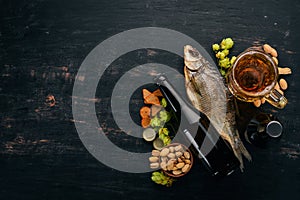 Beer and snacks. Salted crackers, Dried Fish, Chips, Nuts, Peanuts, Pistachios. On a white wooden background.