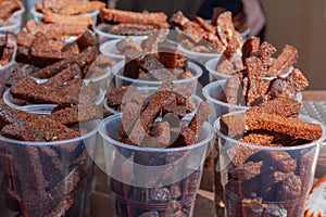 Beer snacks served in plastic cups on table at the food market stall