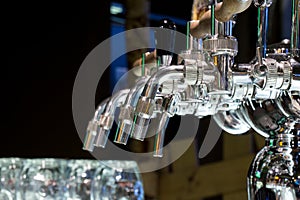 Beer taps and pipes with glasses in the pub.