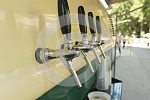 The beer taps in a side of a vintage van