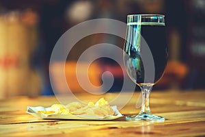 Beer on the wooden table in the pub with free space for your text