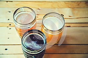 Beer on the wooden table in the pub with free space for your text