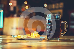 Beer on the wooden table in the pub with free space for your text