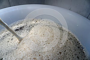 Beer yeast and stirrer in round fermenter - home brewing concept